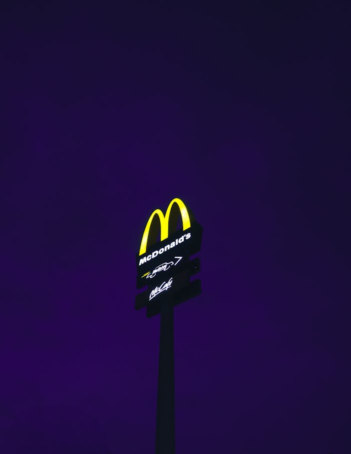 A mcdonald's sign in the dark with purple sky